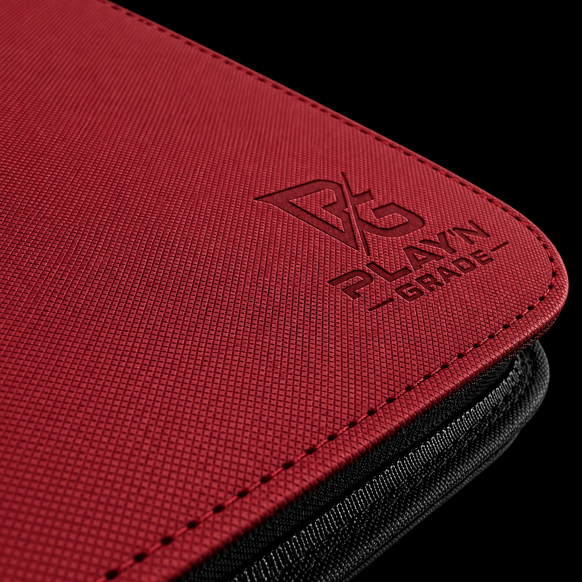 Détail du logo Play’n’Grade, de la texture et du zip noir — classeur rouge